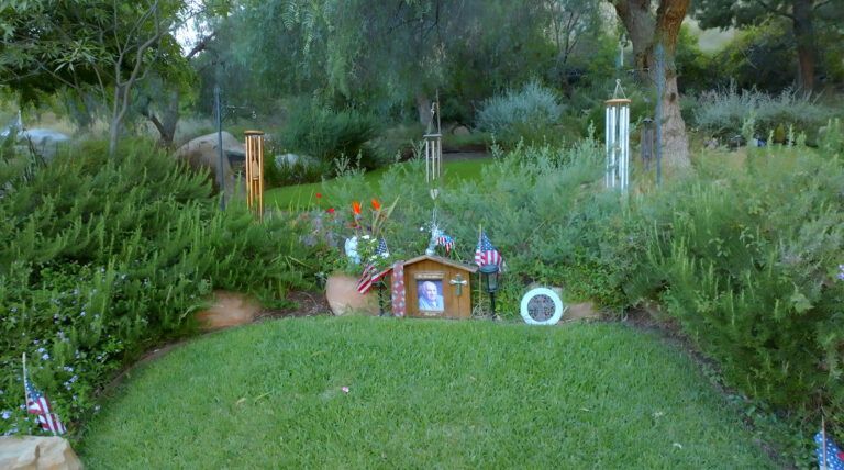 a small house is sitting on top of a lush green hill in a garden .