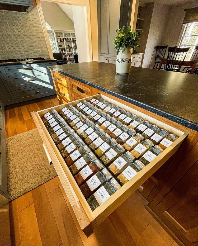 Open kitchen drawer filled with labeled spice jars.