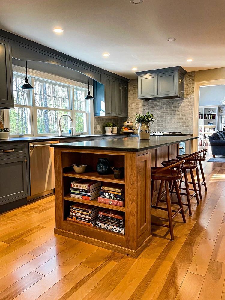 Kitchen with blue cabinets, wood island with bookshelves, and hardwood floors.
