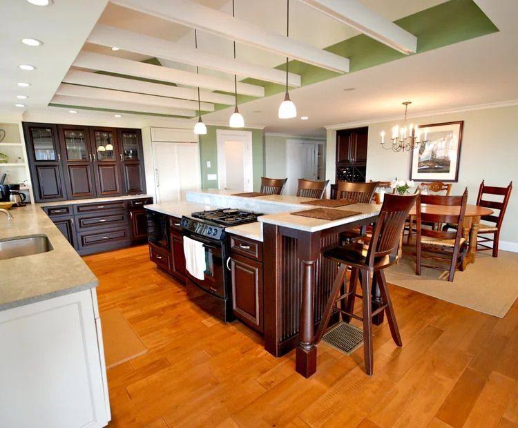 Spacious kitchen with wood cabinets, center island with cooktop and seating.