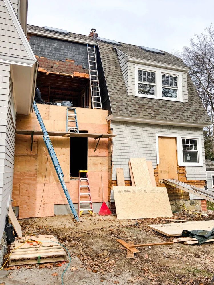 House exterior under construction, exposed walls with plywood and insulation.