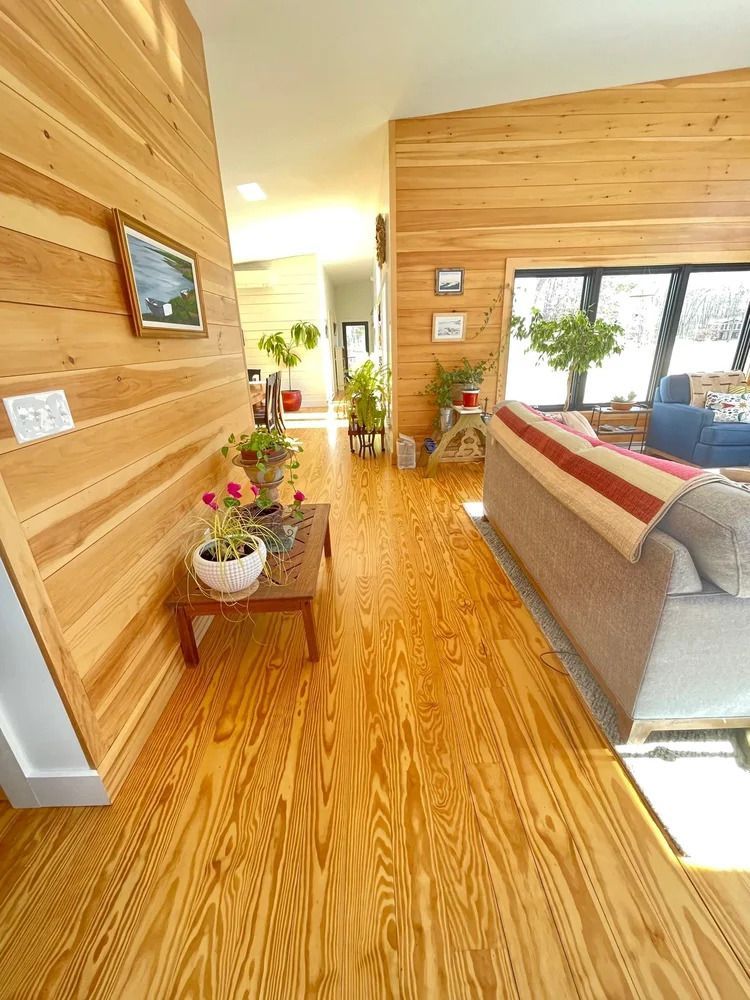 Wooden-paneled hallway with wood floors, small table, plants, and a sofa. New Construction in Kennebunkport, Maine