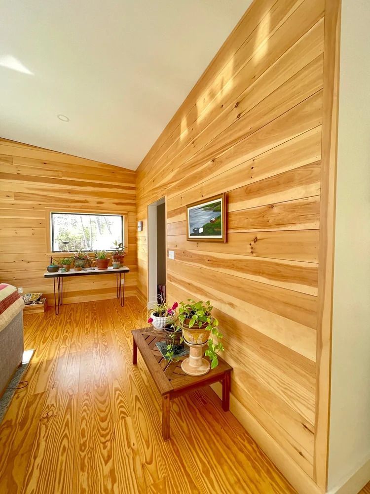 Wooden paneled interior with a window, plants, and art.