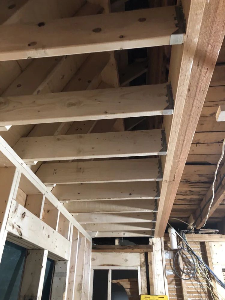 Wooden joists and framing in a construction setting, seen from below.