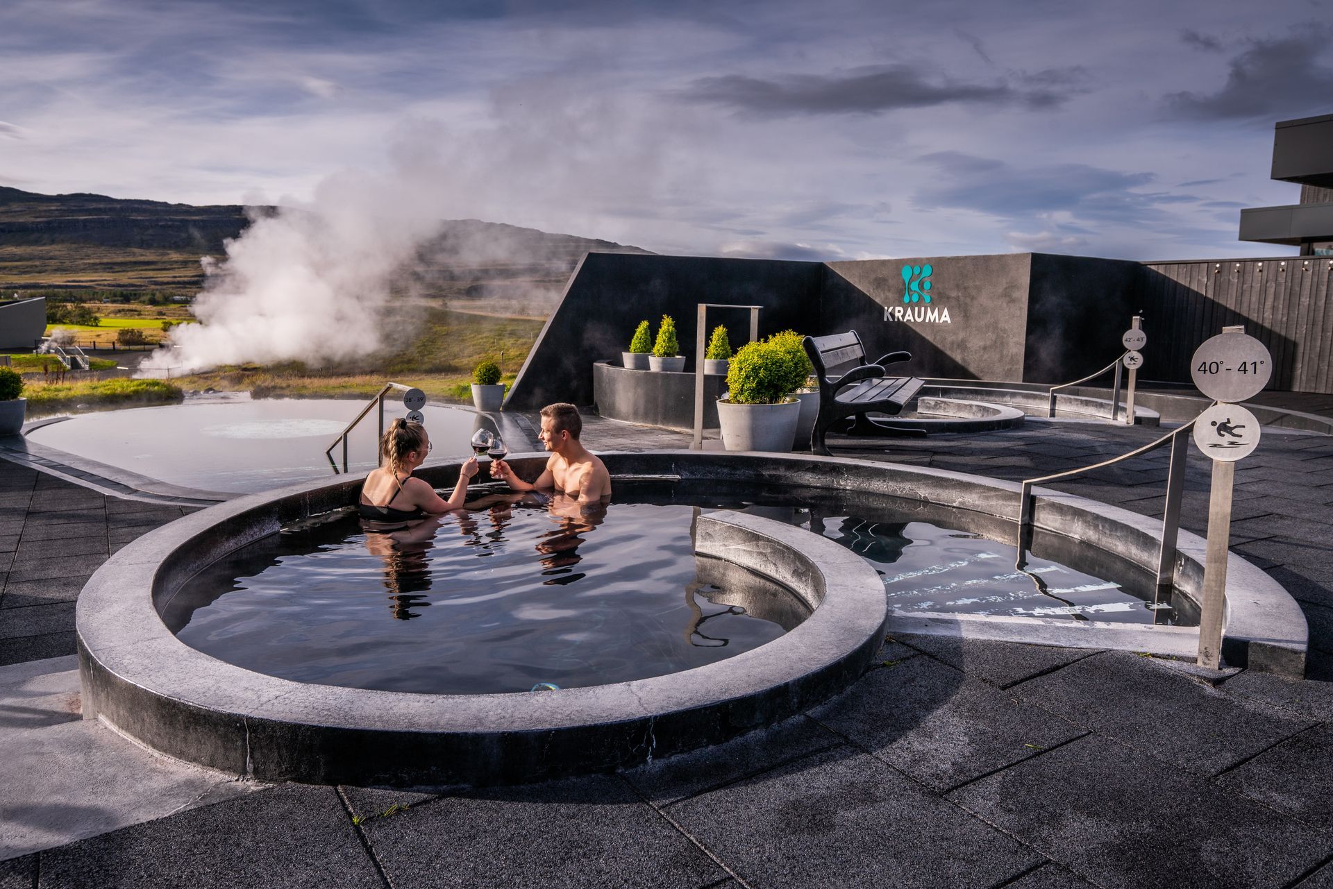 A couple sitting in the geothermal pools at Krauma