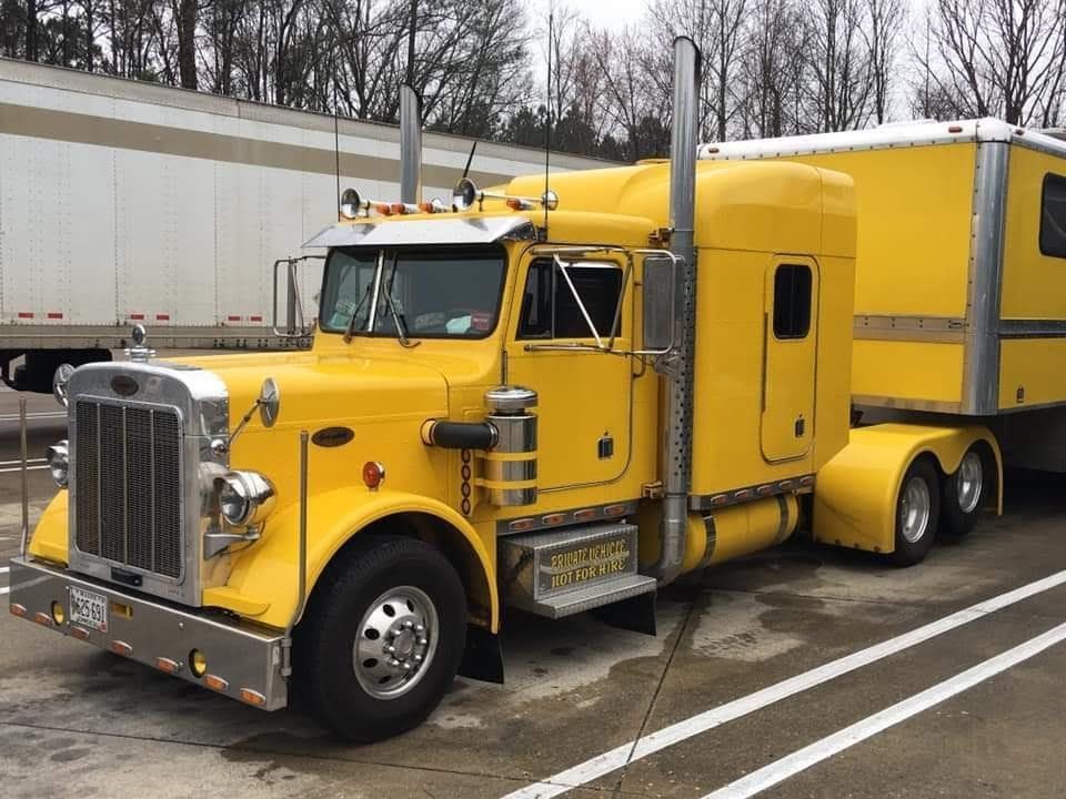A yellow semi truck with a trailer attached to it