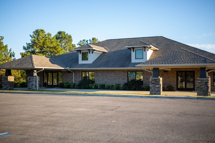 A large brick building with a parking lot in front of it.