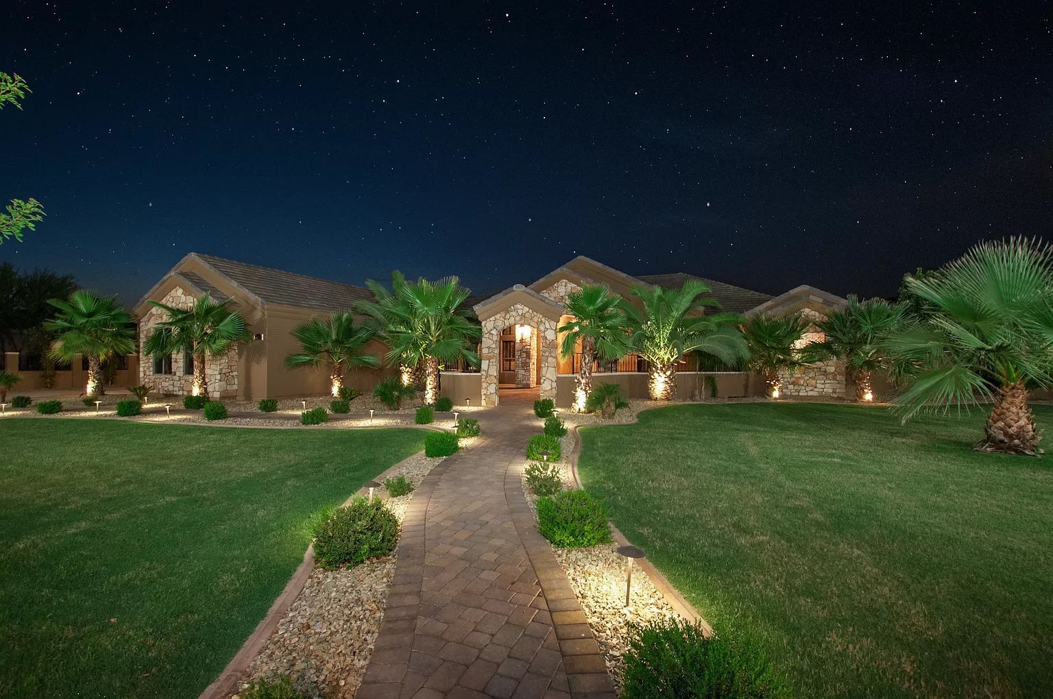A large house with a path leading to it at night