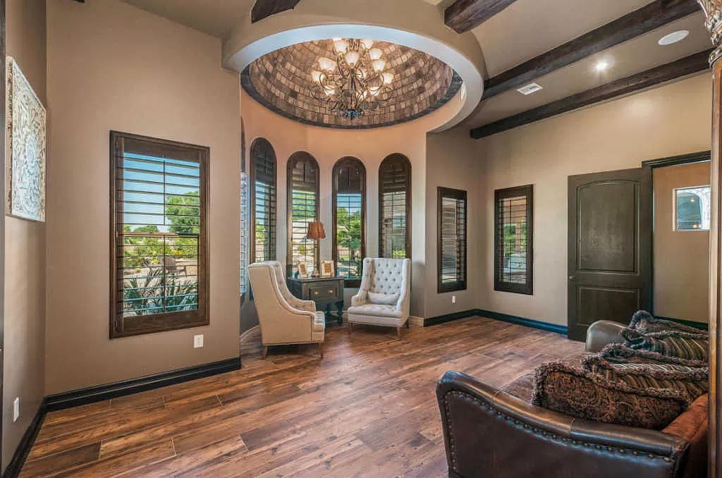 A living room with hardwood floors and a chandelier hanging from the ceiling.