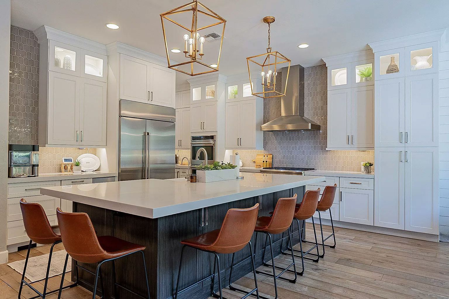 A kitchen with white cabinets , stainless steel appliances , and a large island.