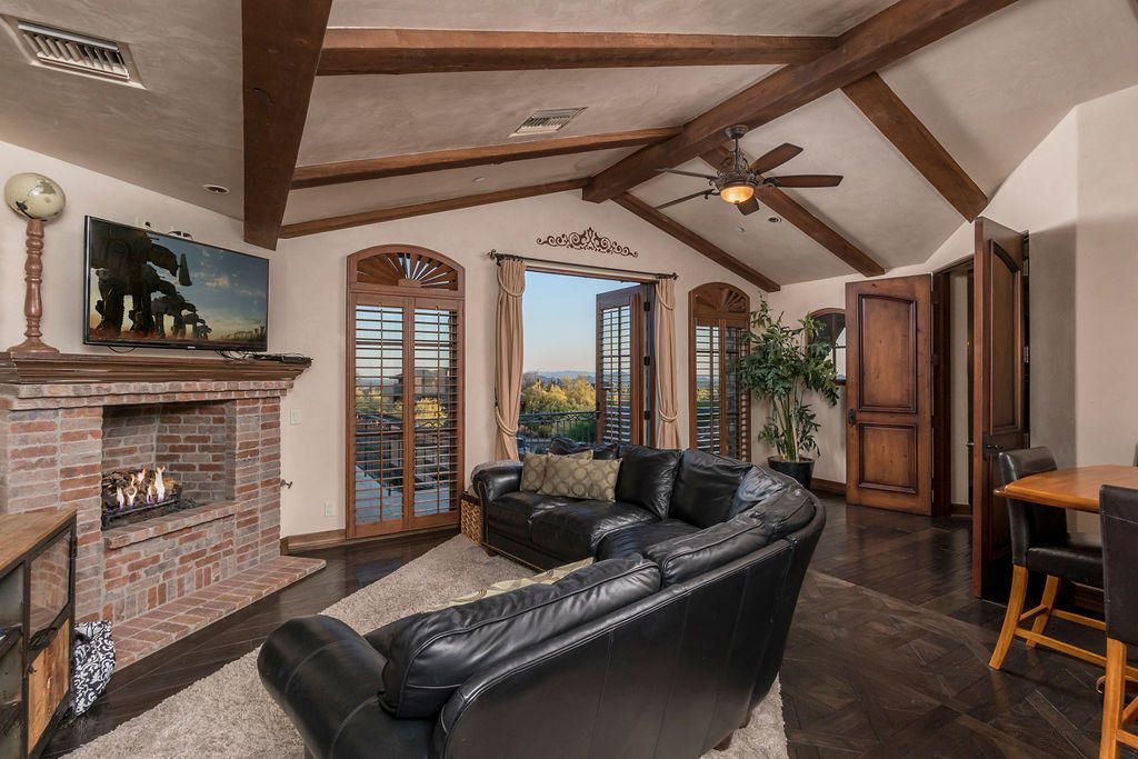 A living room with a fireplace and a ceiling fan
