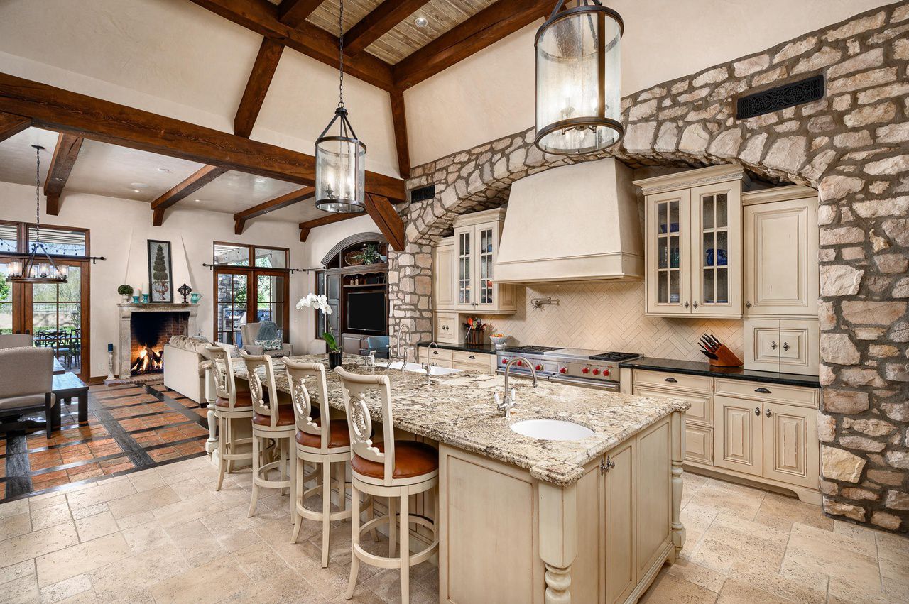 A large kitchen with granite counter tops and white cabinets