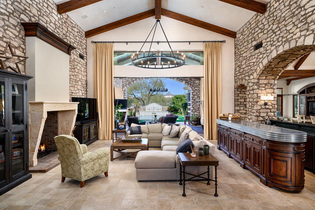 A living room with a large sectional couch and a fireplace