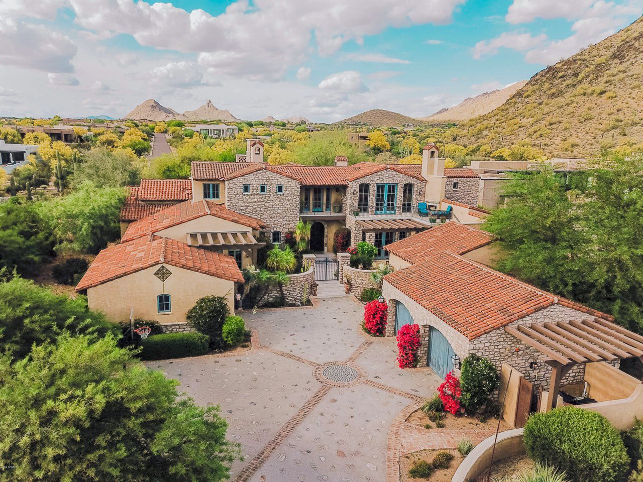 An aerial view of a large house surrounded by trees and mountains.
