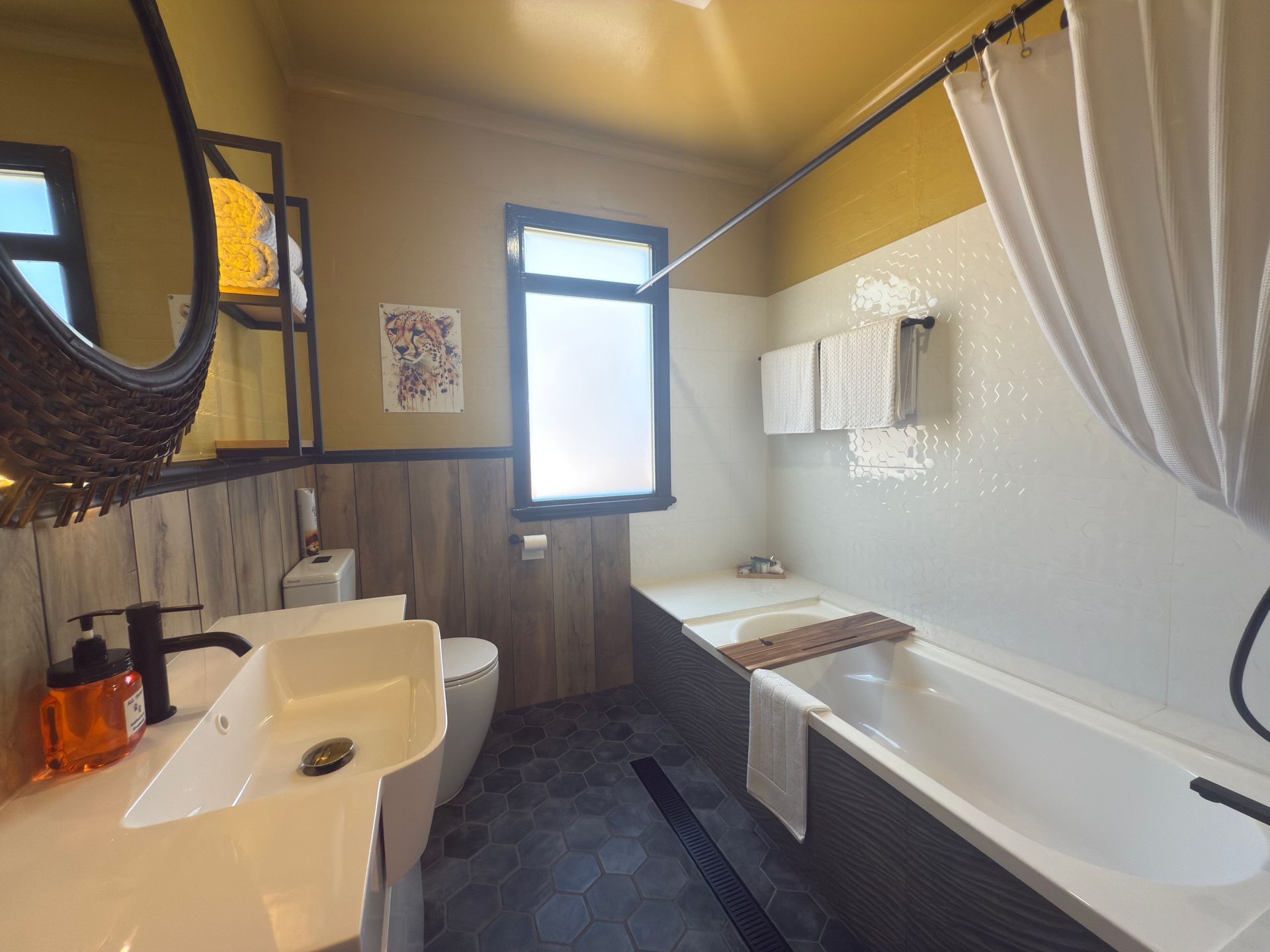 A bathroom with a sink , toilet , bathtub and mirror.