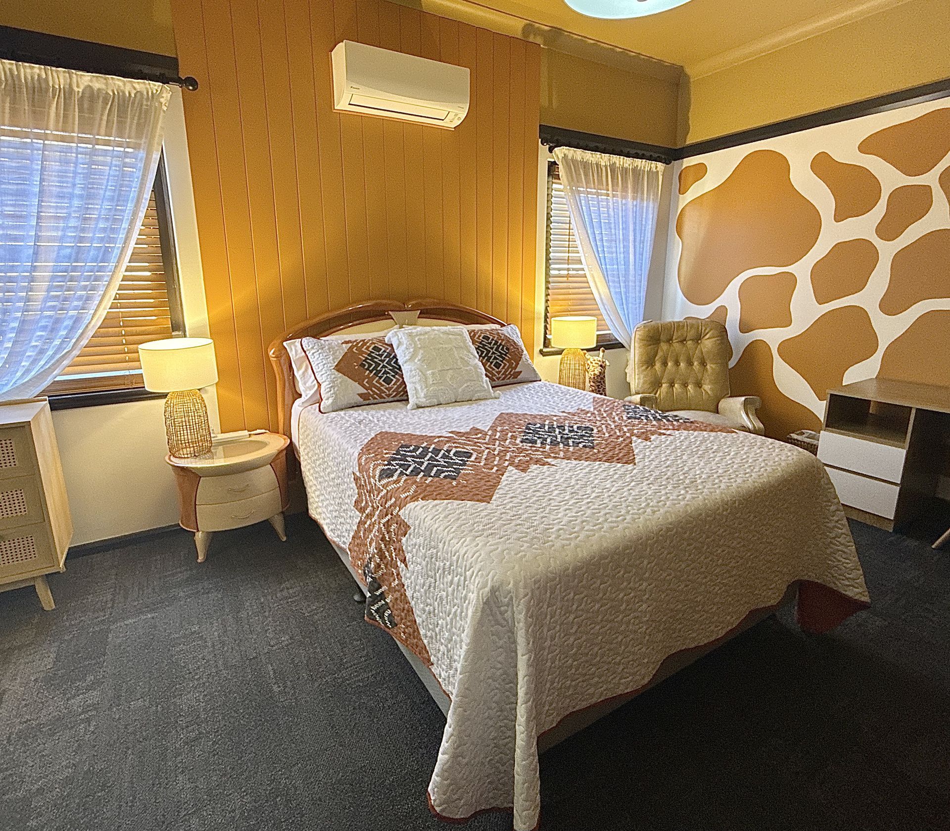 A bedroom with a giraffe print on the wall and a bed