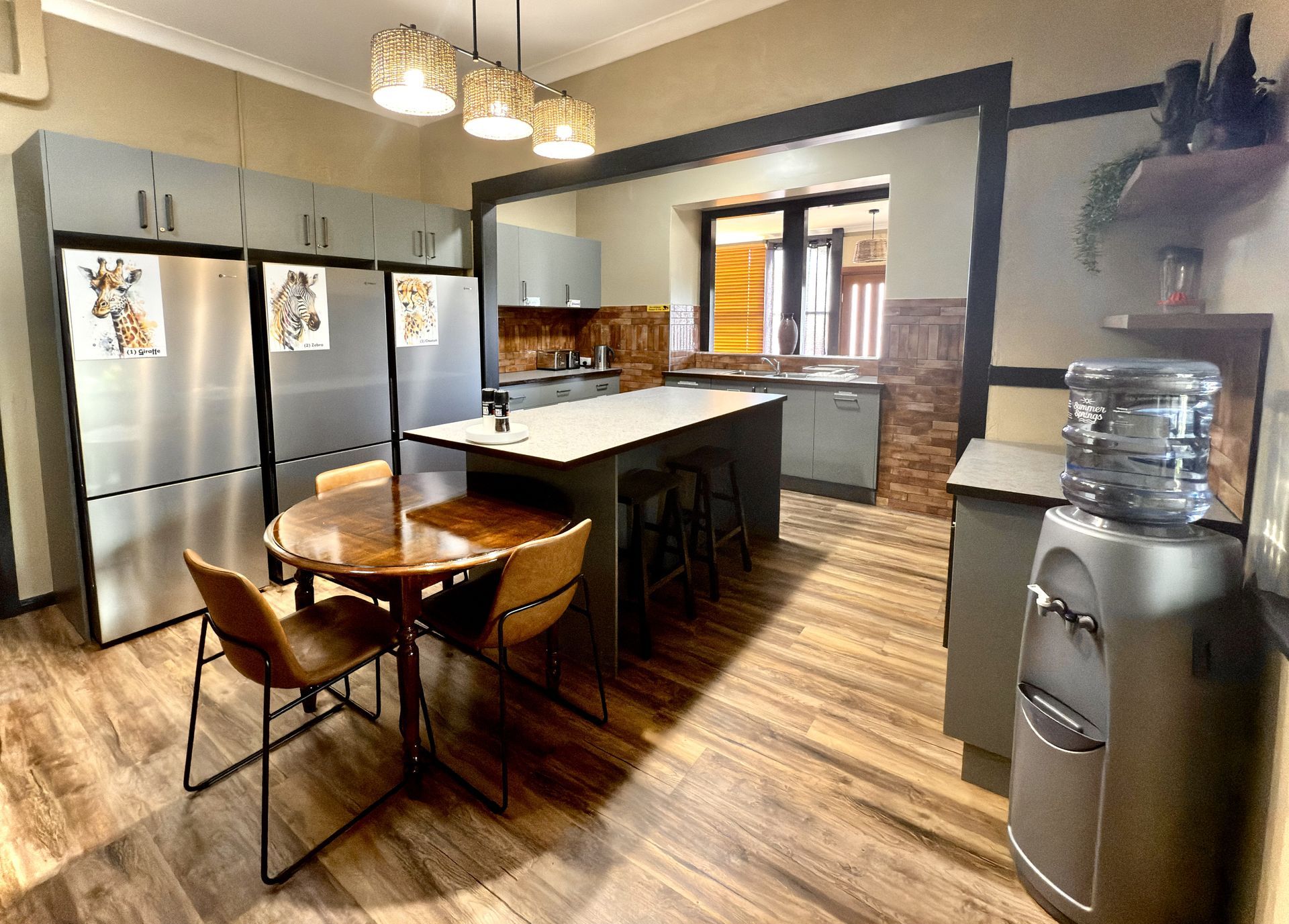 A kitchen with a table and chairs and a water dispenser.