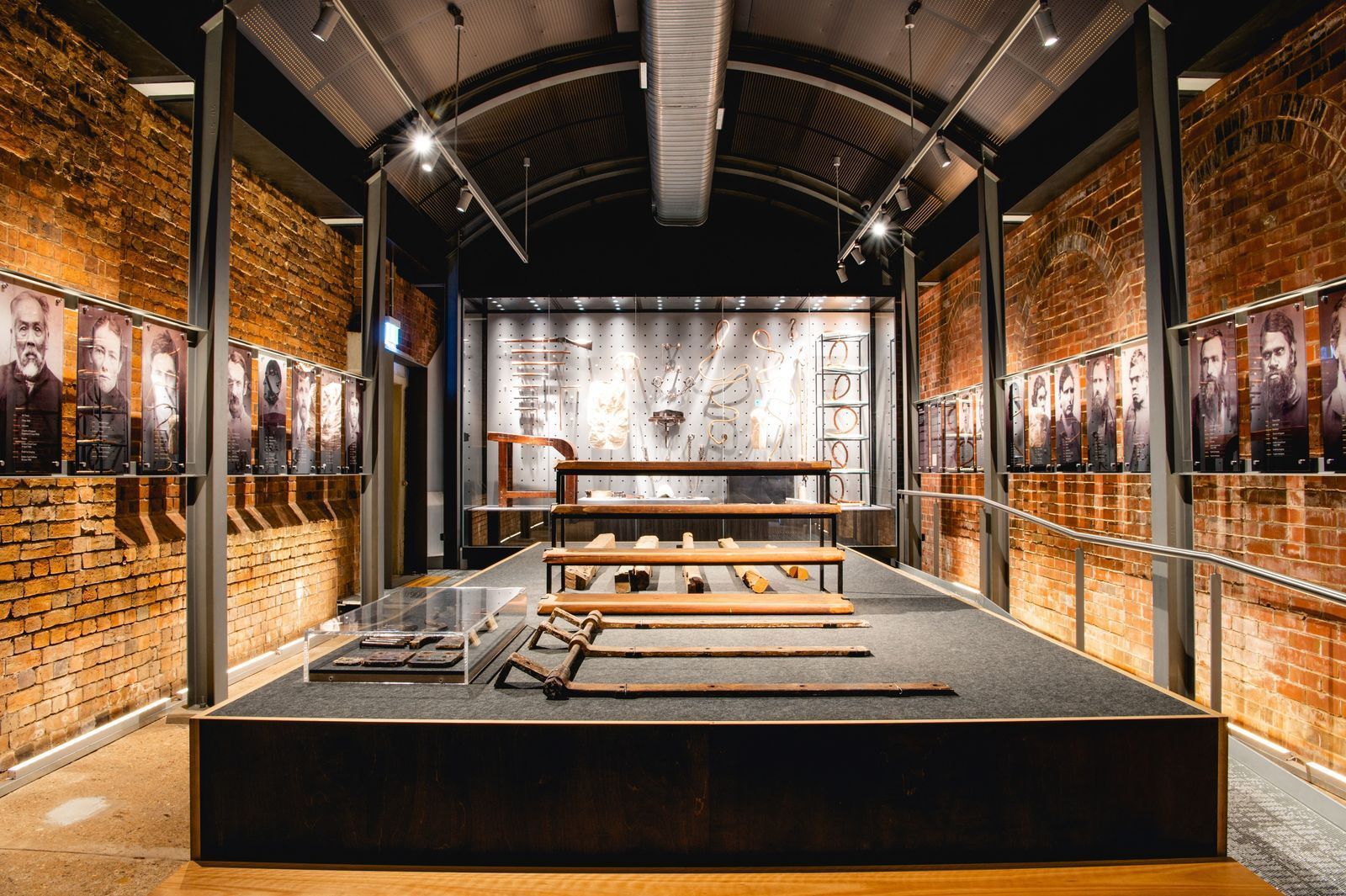 A large room with a stage and a brick wall.