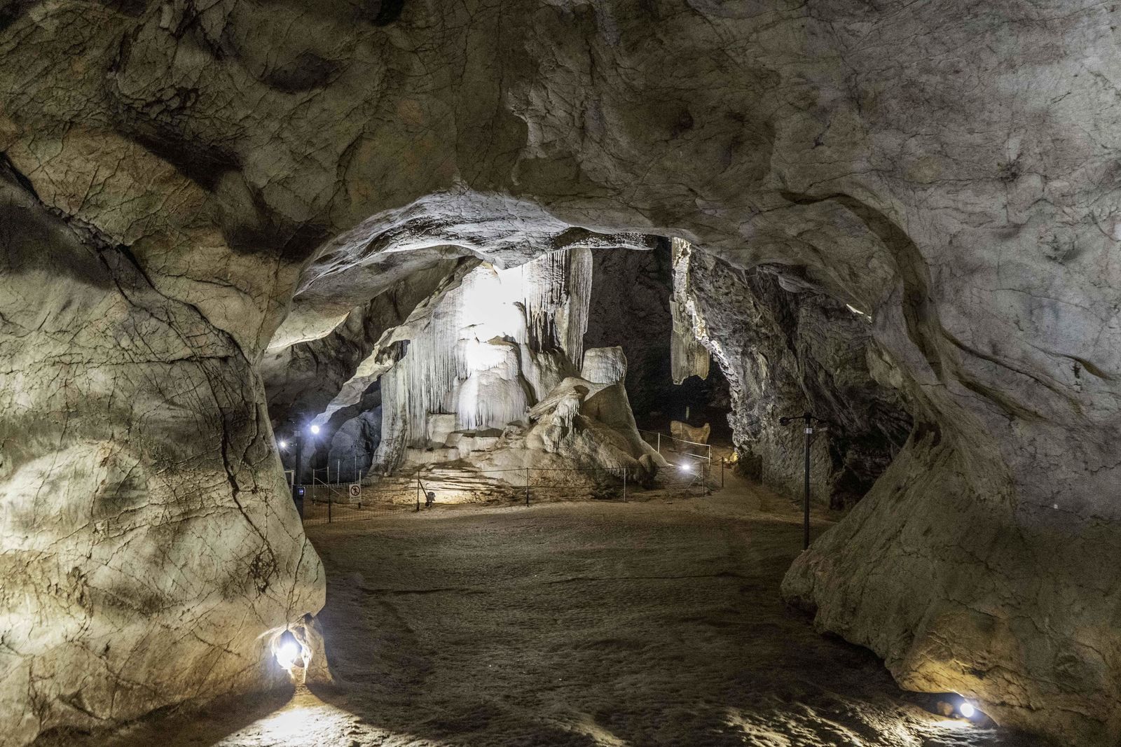 A person is walking through a cave with a lot of rocks.