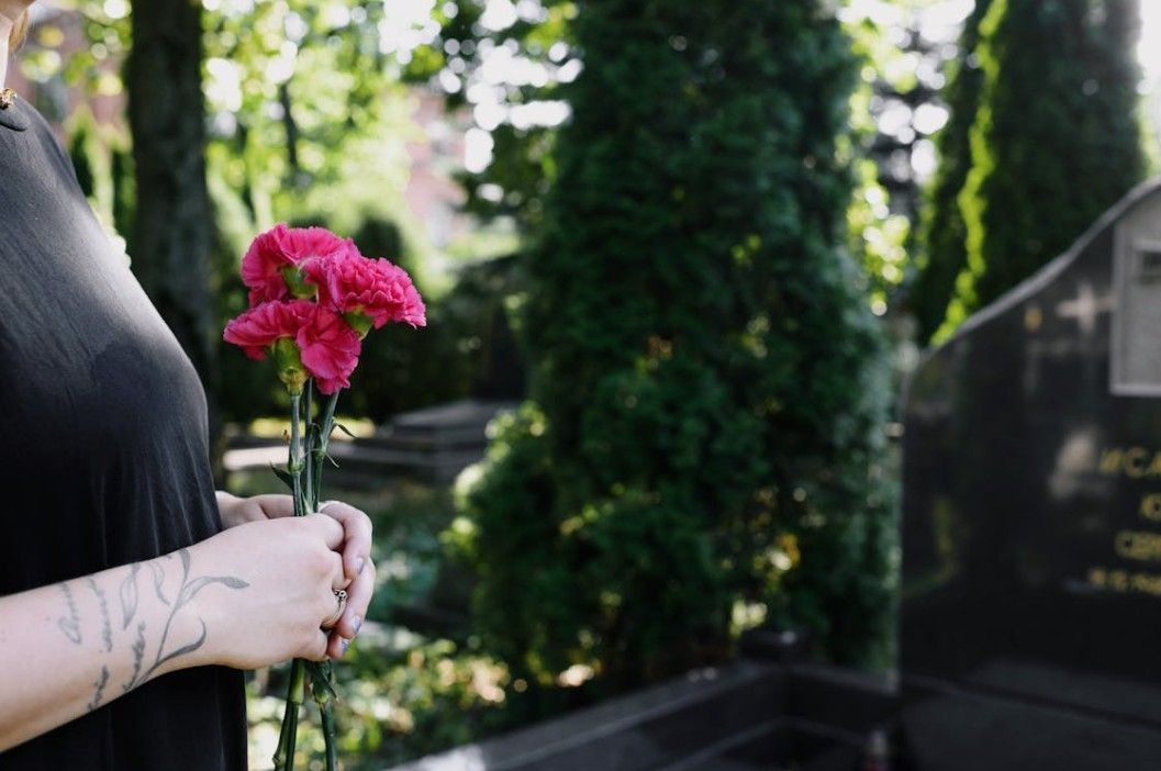 Family member holding flowers at a graveside service for funeral and cremation care in Rock Falls, IL