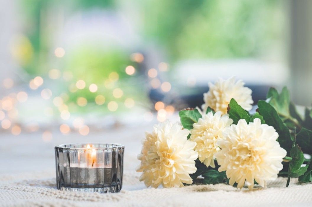 Memorial candle and white flowers for compassionate cremation services in Sterling, IL