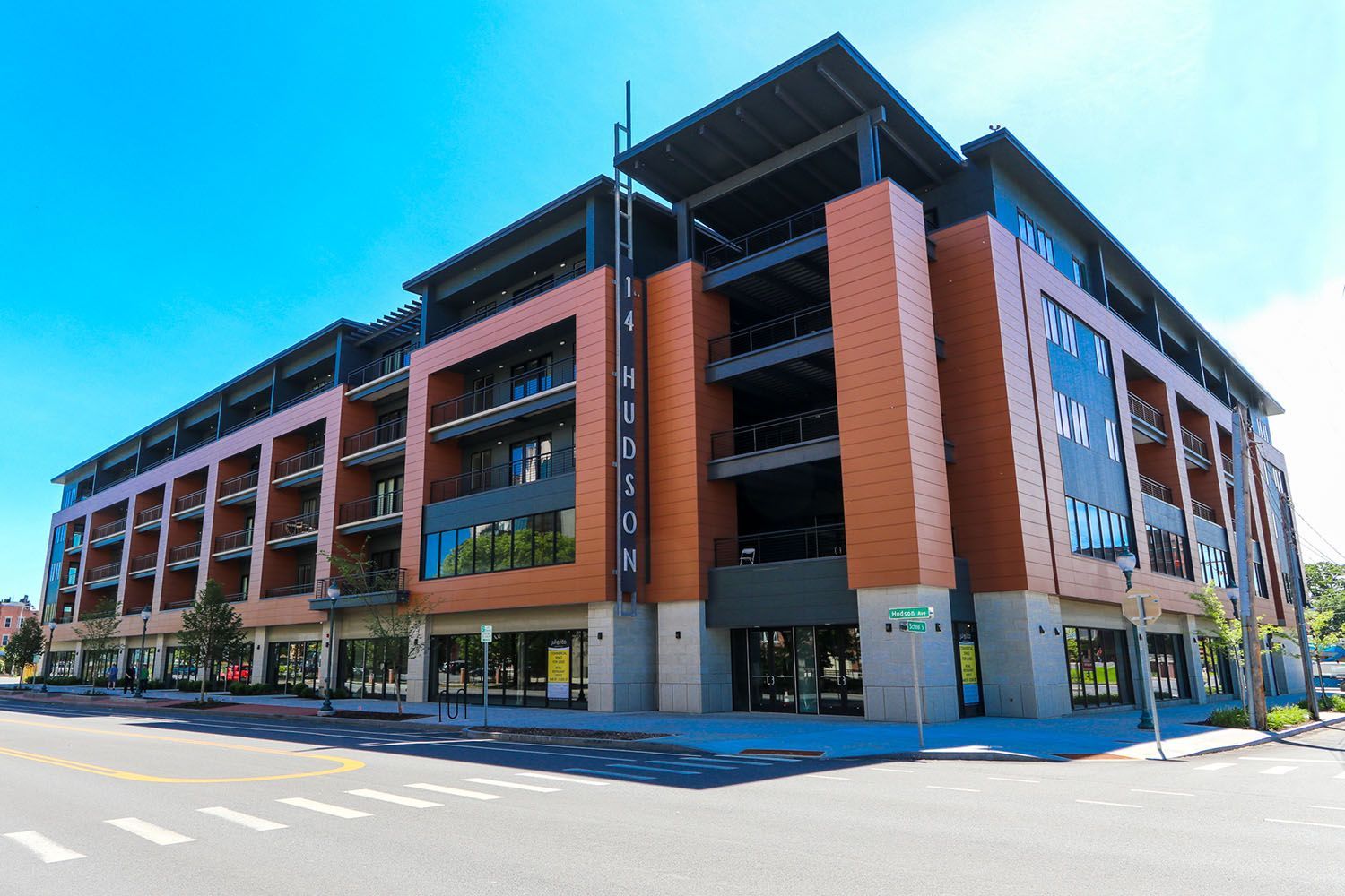 A large brick building is sitting on the corner of a city street.
