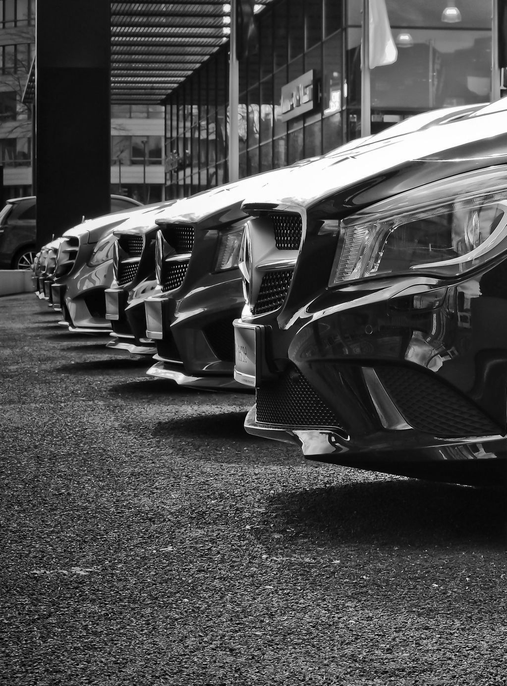 Line of black cars parked in front of a building.