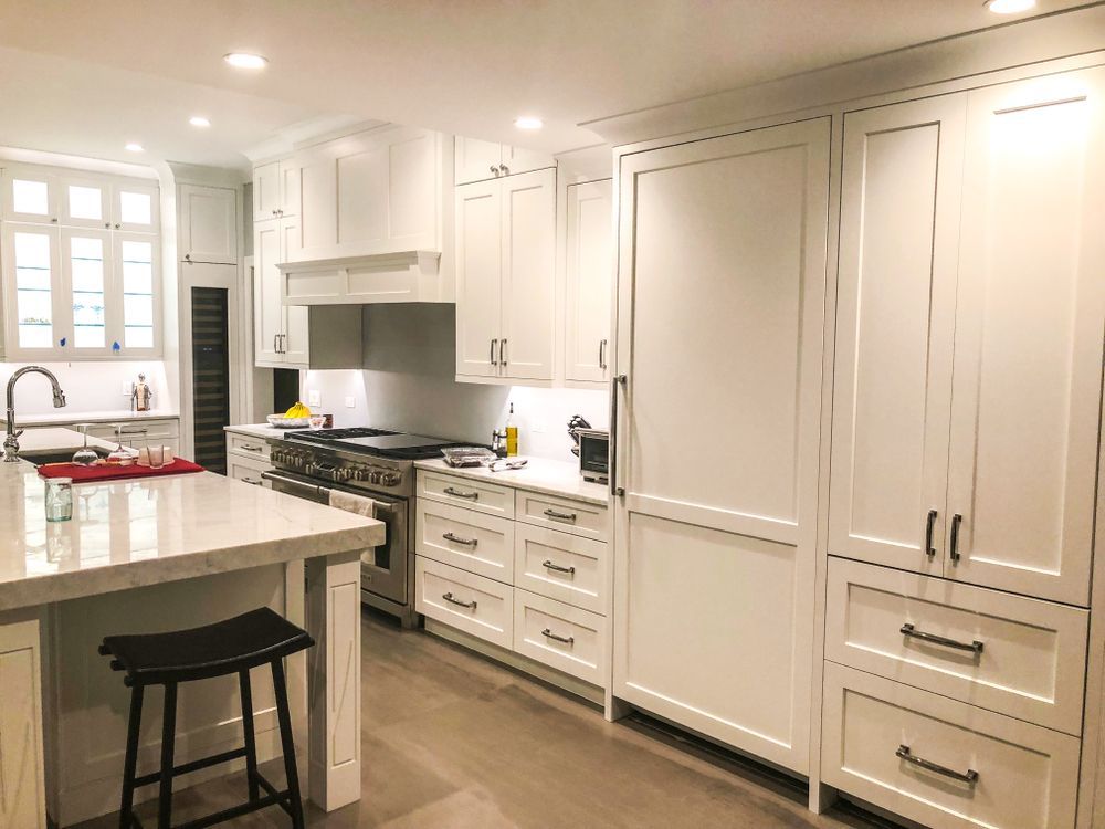 White Kitchen With Cabinetry, Island, and Appliances