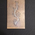 Brown rectangular artwork with a white fractal lightning-like design down the center.