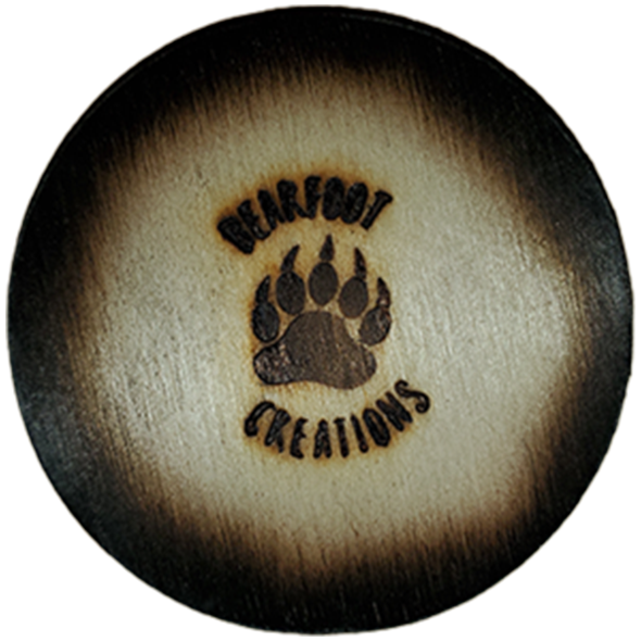 Round wooden coaster with charred edges, logo reads 