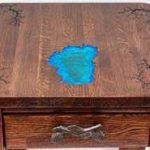 Wooden table with a blue resin inlay, and a drawer with a unique handle.