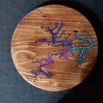 Round wooden tray with colorful fractal design; blue, purple, and teal.