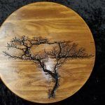 Wood round with a burnt tree design.