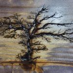 Burnt wood art: a tree silhouette, branches reach, against a gradient wooden background.