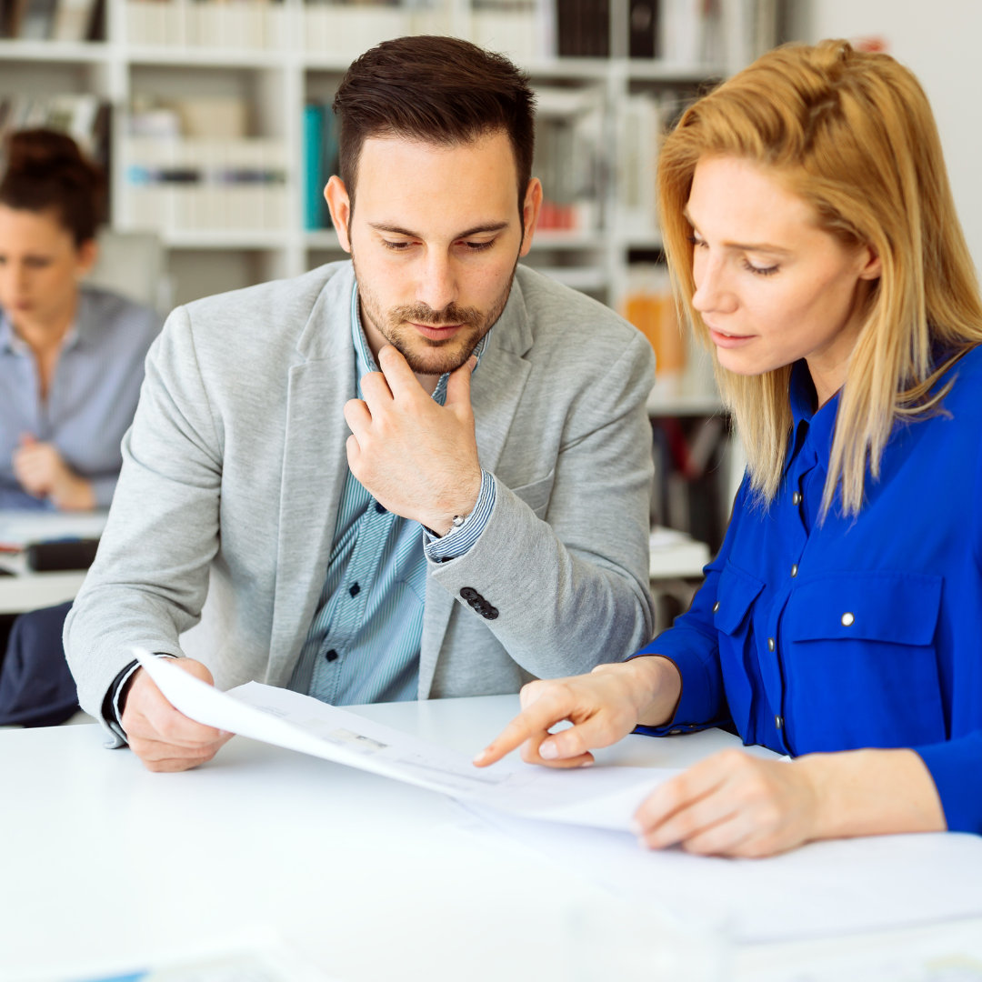 Privacy Policy is important for every website. A man and a woman are sitting at a table looking at a piece of paper.