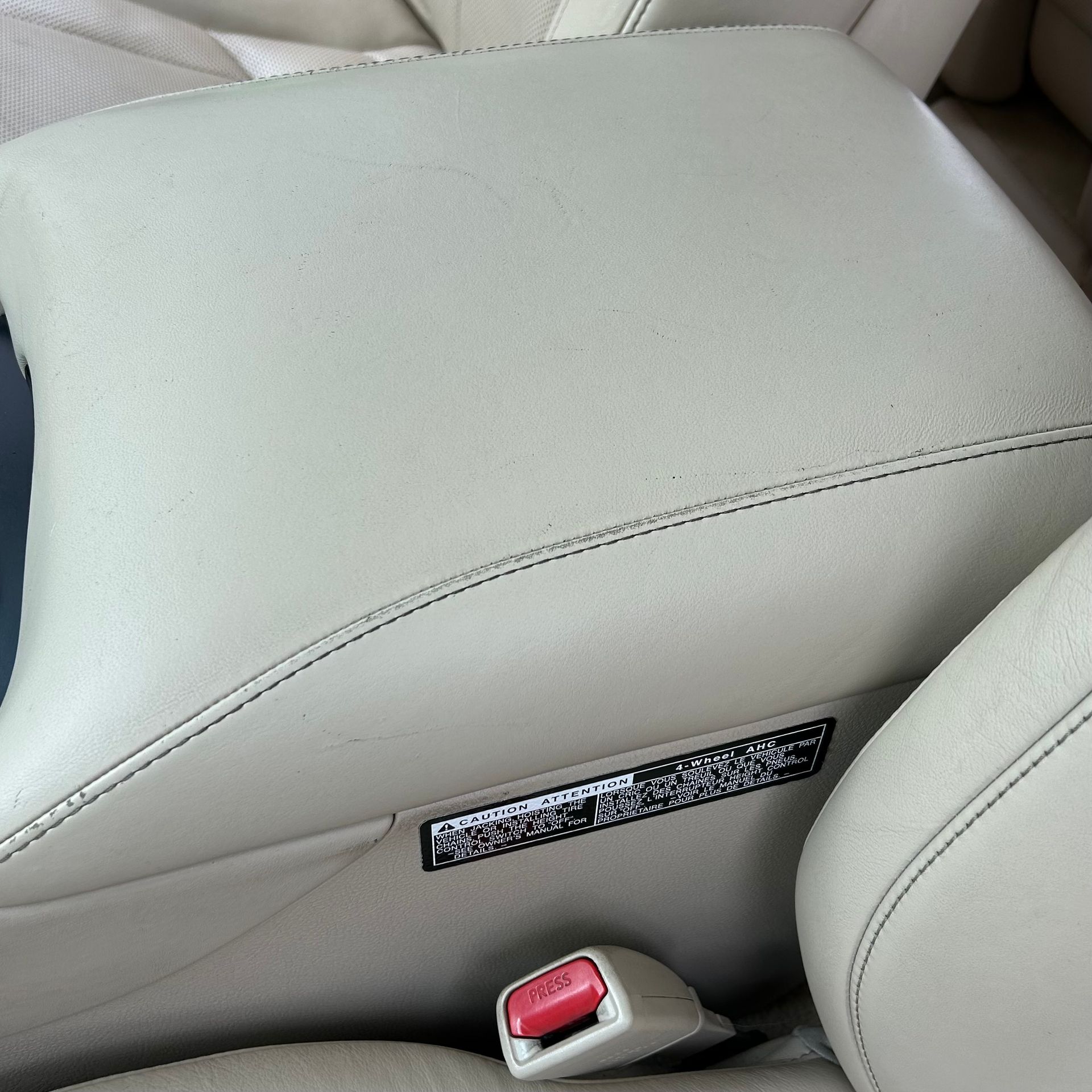 A close up of a car seat with a red seat belt buckle