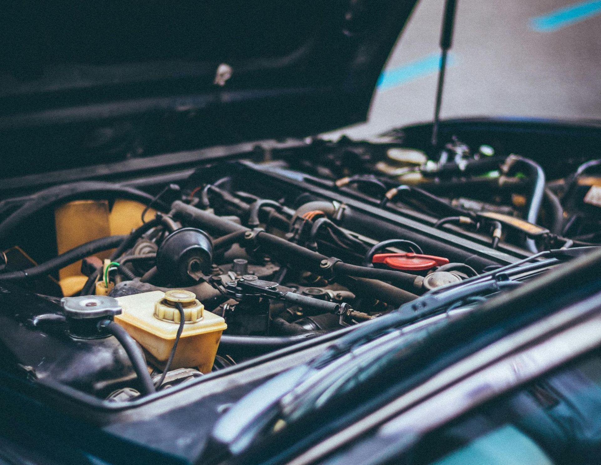 The hood of a car is open and the engine is visible.