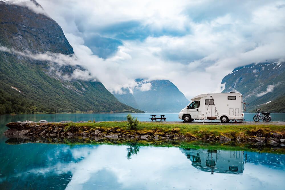A Rv Is Parked Next To A Lake In The Mountains — Affordable Caravan Repairs in Bundaberg, QLD