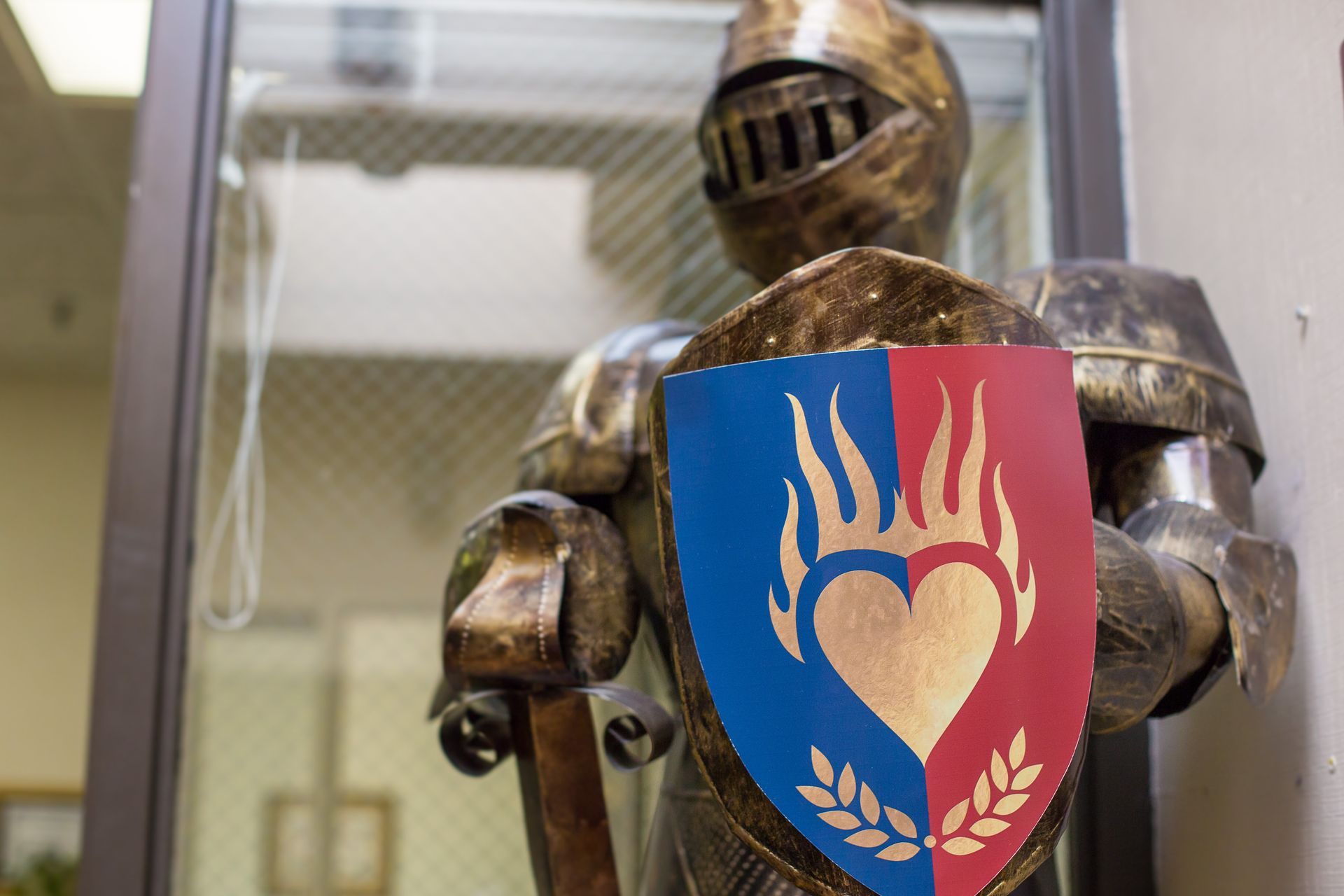 A statue of a knight holding a shield with a heart on it