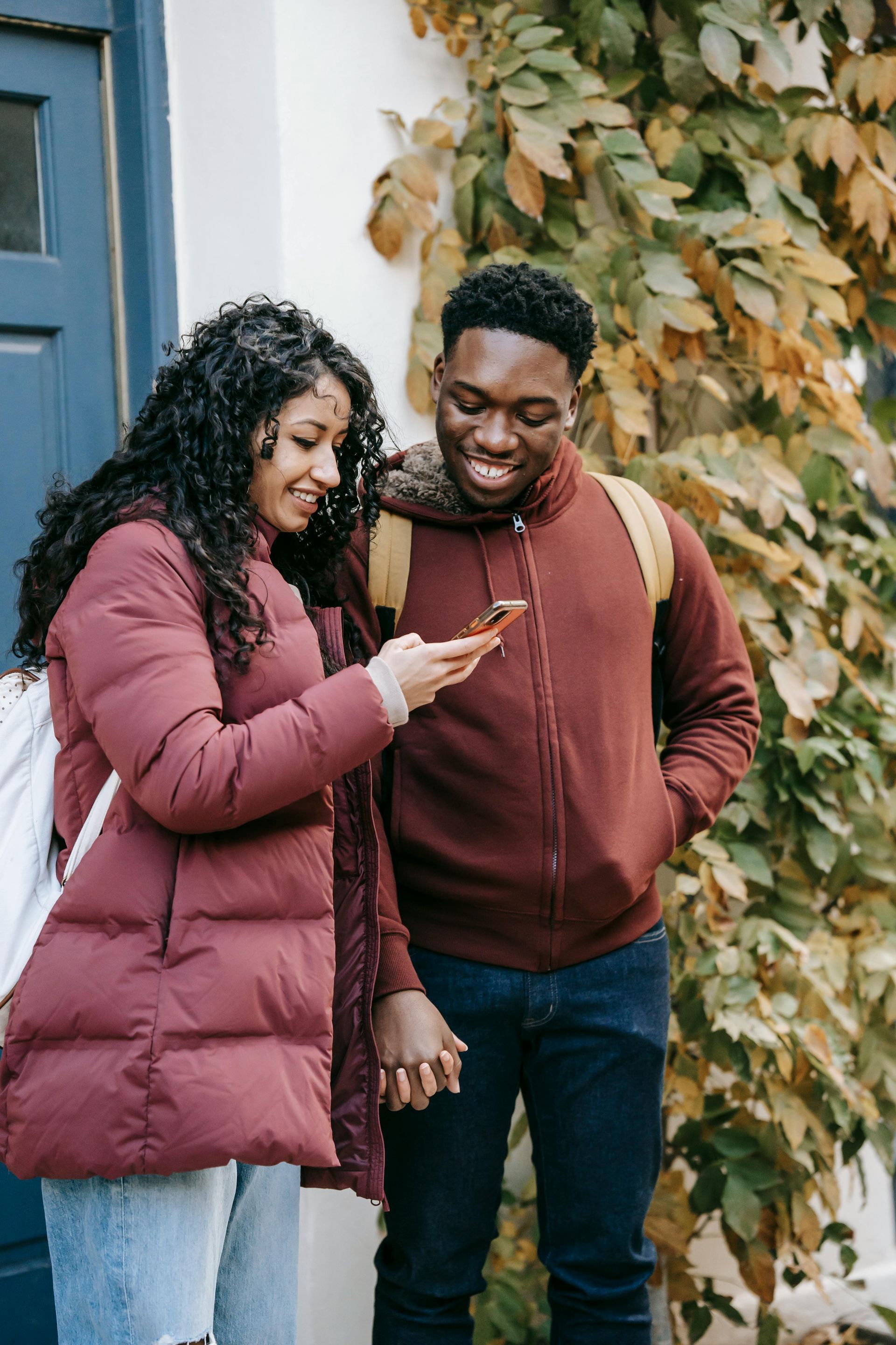 A man and a woman are looking at a cell phone