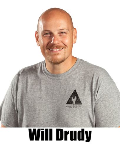 Bald man, Will Drudy, smiling in a grey t-shirt with logo. | Auto Source Of West Michigan