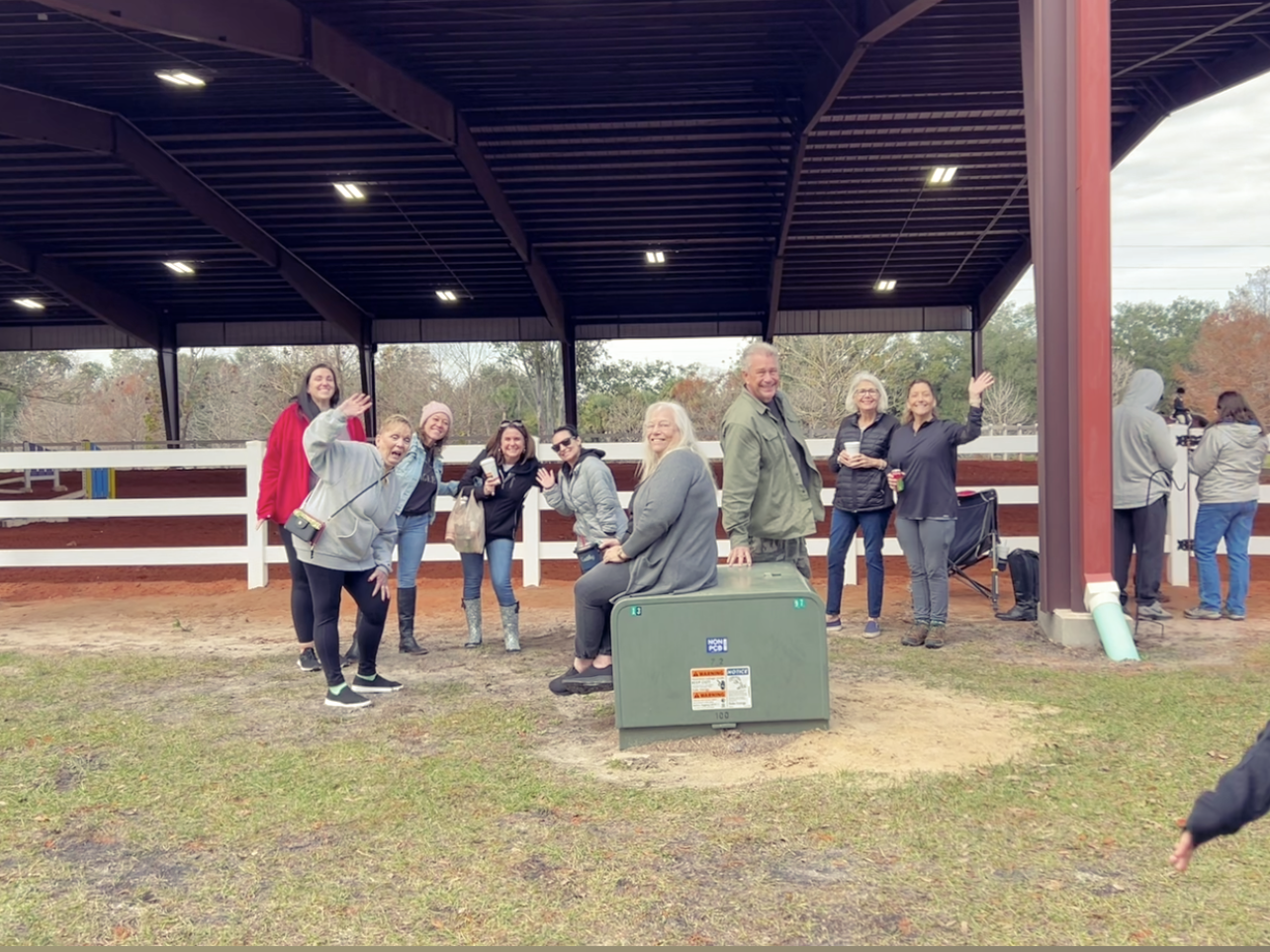 A group of people are posing for a picture under a covered area.