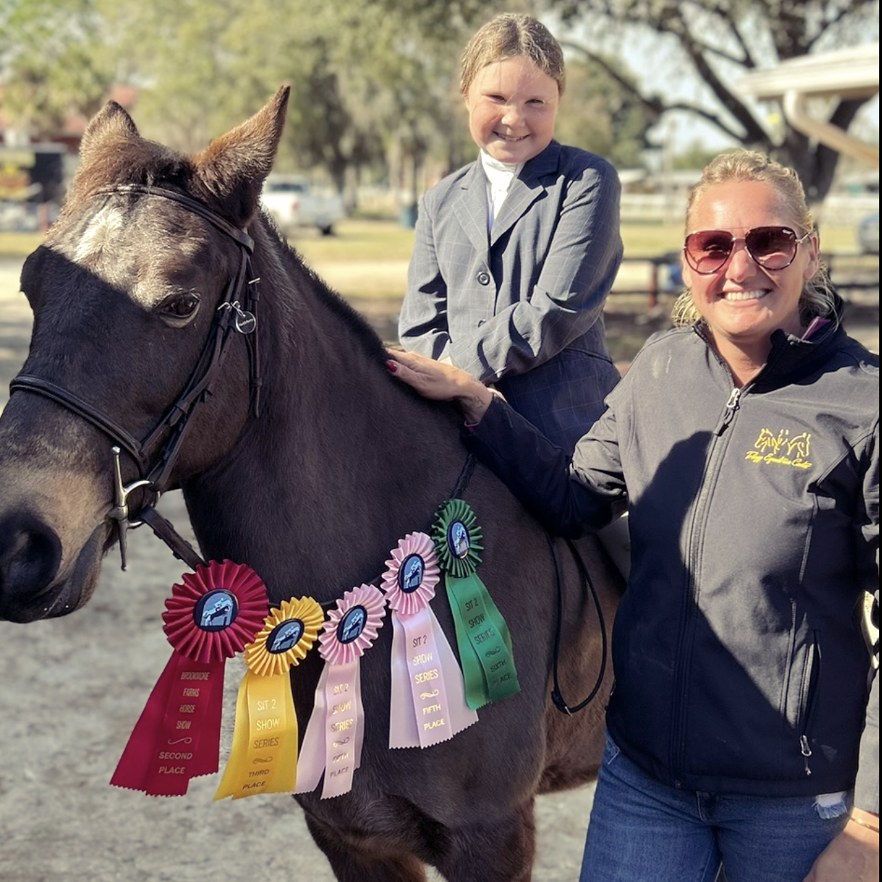 A little girl is riding on the back of a brown horse