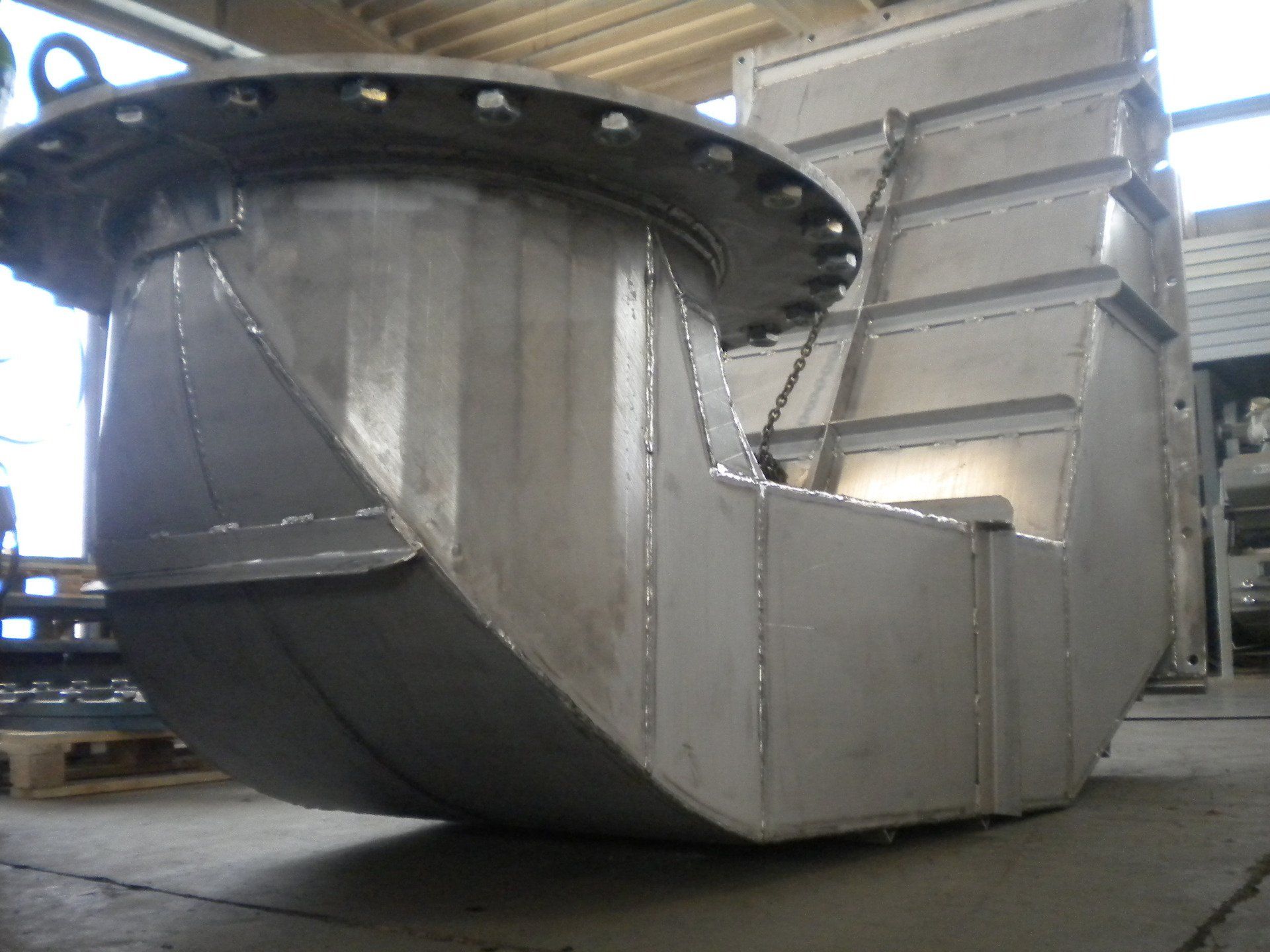 Un grande oggetto metallico è appoggiato sul pavimento di una stanza.