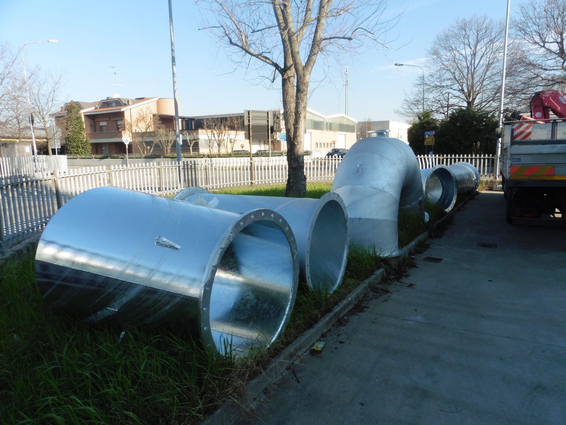 Un mucchio di tubi metallici sono appoggiati sul ciglio della strada