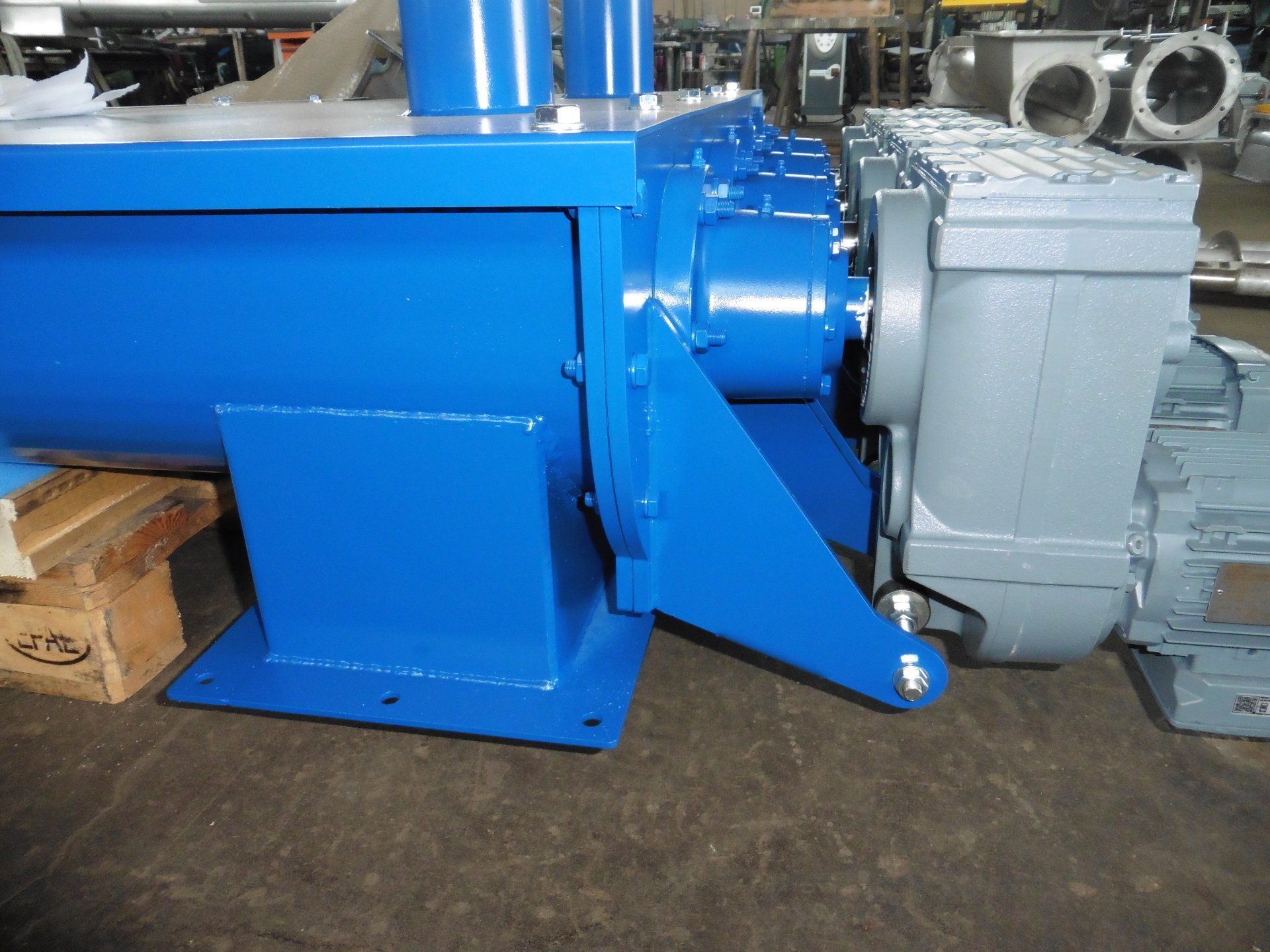 Una macchina blu è appoggiata su un pallet di legno