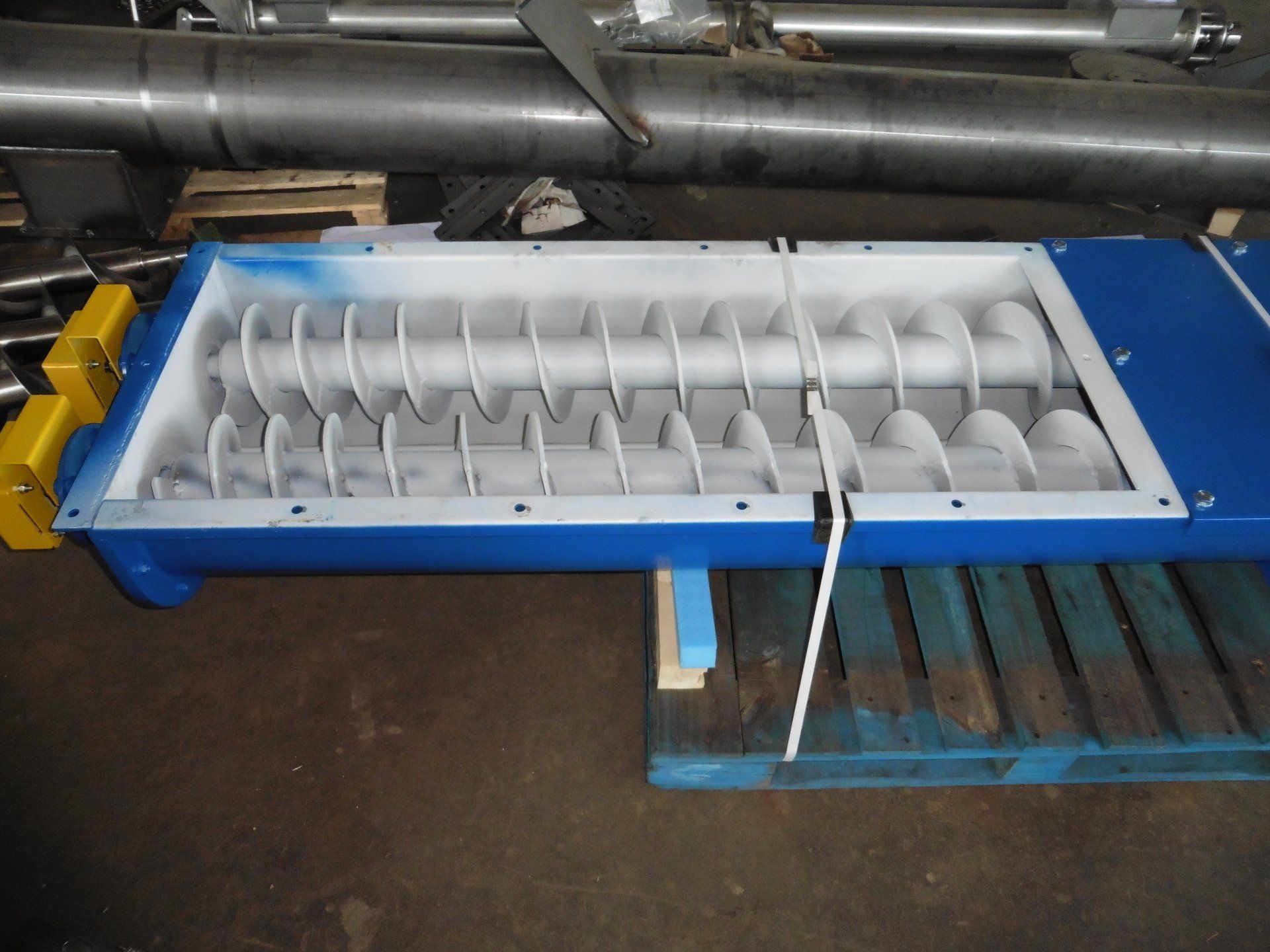 Una macchina blu e bianca è appoggiata su un pallet di legno