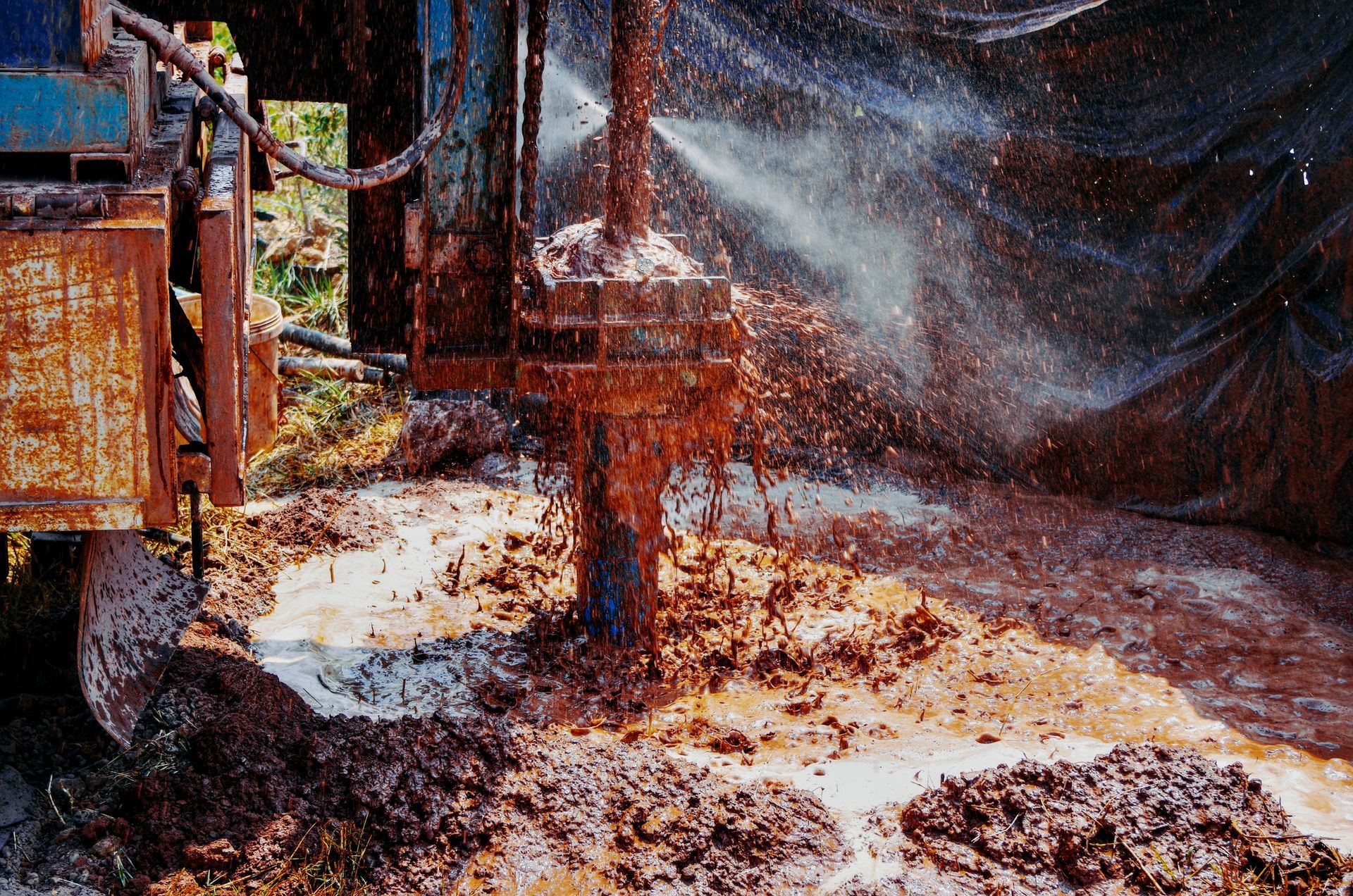 A machine is working in a muddy area with water spraying out of itGrundfos