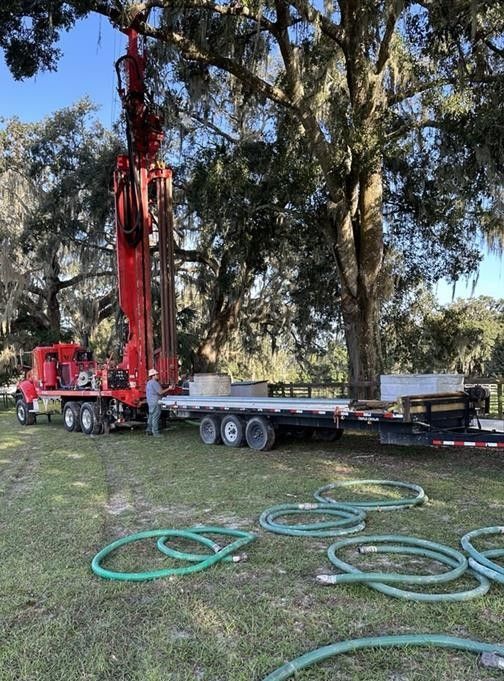 A large white water tank is sitting on top of a concrete platform.