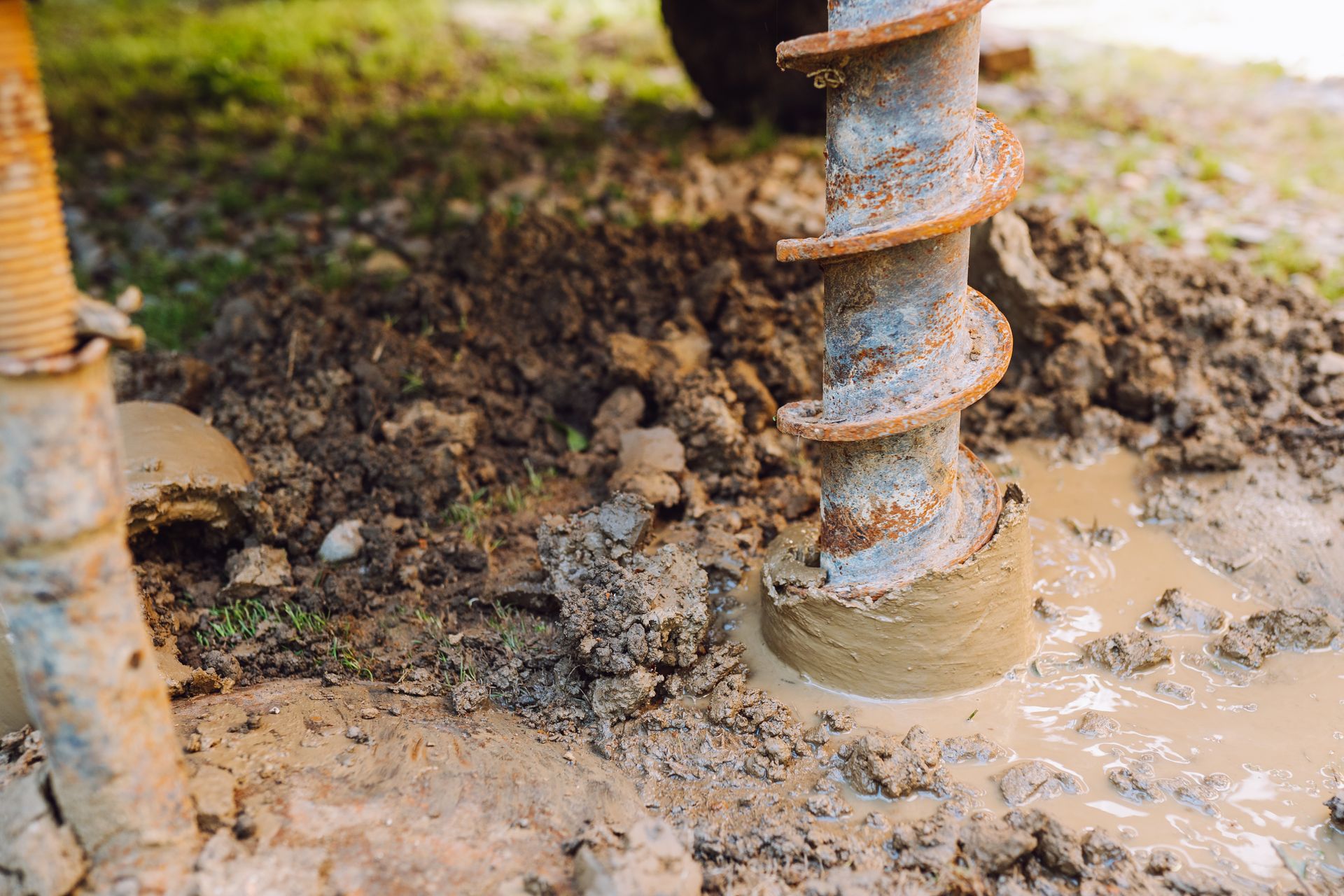 A person is using a drill to dig a hole in the ground.